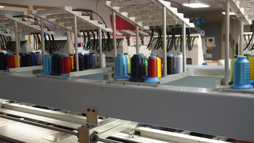 Embroidery thread spools on a Barudan embroidery machine at Generation Embroidery