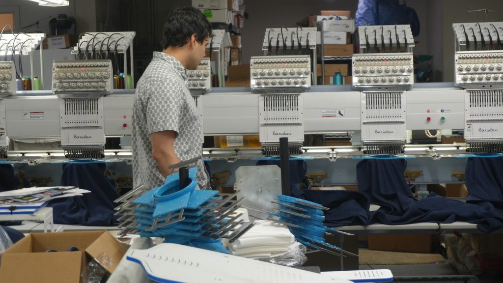 Jordan Gonzales operating an embroidery machine at Generation Embroidery in Pewaukee, Wisconsin