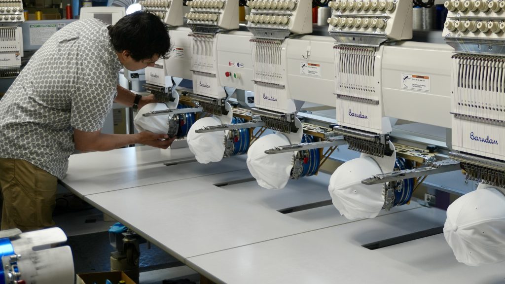 Jordan embroidering some hats on a Barudan embroidery machine 